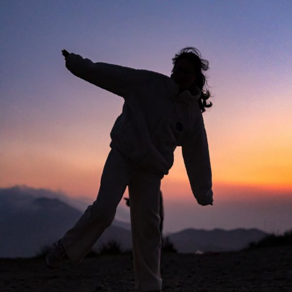 Person stretching arms towards the sky in nature